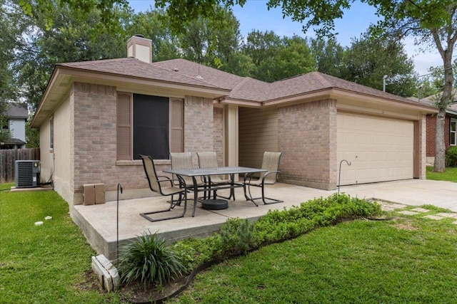 110 Hummingbird Ct, Cedar Creek, TX 78612 - rear view of house featuring brick siding, central AC, an attached garage, and a chimney