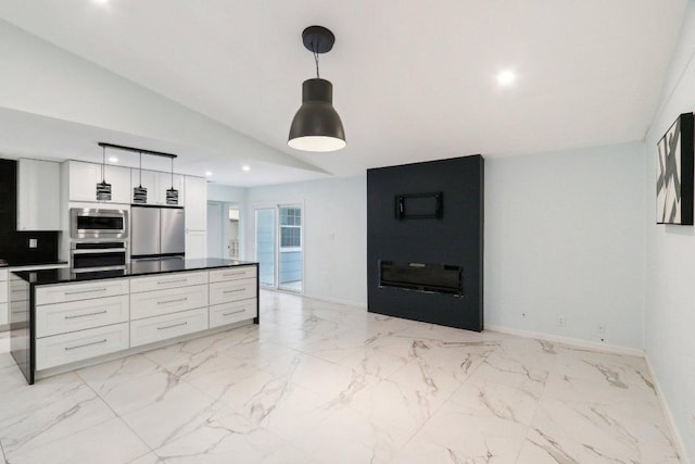 309 Northwood Dr, Georgetown, TX 78628 - kitchen featuring appliances with stainless steel finishes, white cabinets, dark countertops, hanging light fixtures, and vaulted ceiling