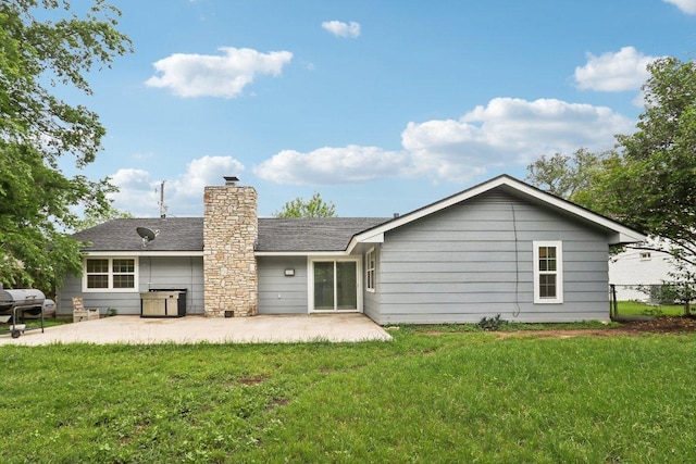 309 Northwood Dr, Georgetown, TX 78628 - back of property with a patio, a lawn, a chimney, and a shingled roof
