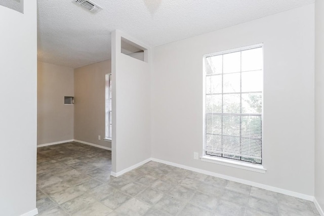 7301 Scenic Brook Dr, Austin, TX 78736 - empty room featuring healthy amount of natural light, a textured ceiling, and baseboards