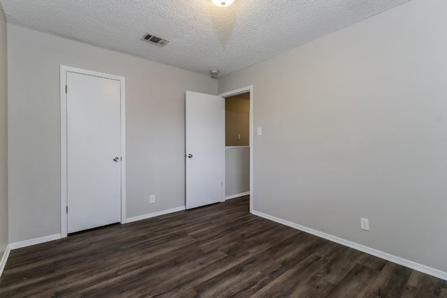 7301 Scenic Brook Dr, Austin, TX 78736 - unfurnished bedroom with dark wood-type flooring, baseboards, and a textured ceiling