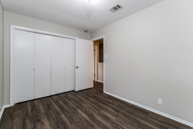 7301 Scenic Brook Dr, Austin, TX 78736 - unfurnished bedroom featuring dark wood-style flooring, a textured ceiling, a closet, and baseboards