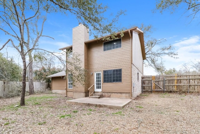 7301 Scenic Brook Dr, Austin, TX 78736 - rear view of house featuring entry steps, a chimney, a fenced backyard, a patio area, and a gate