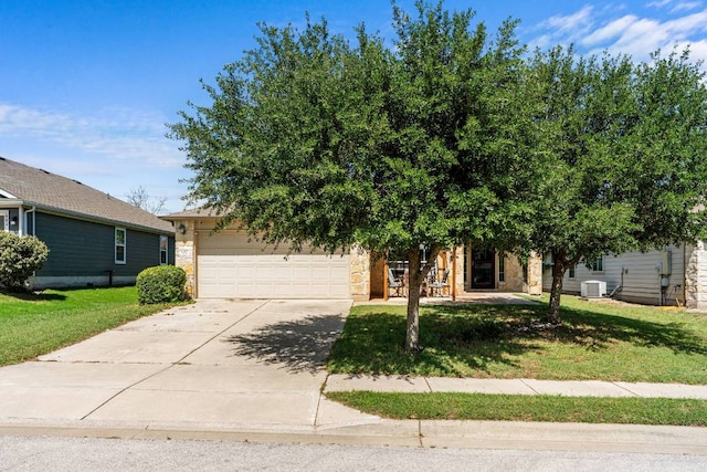 604 Comal Run, Hutto, TX 78634 - view of property hidden behind natural elements featuring concrete driveway, stone siding, a front yard, and an attached garage