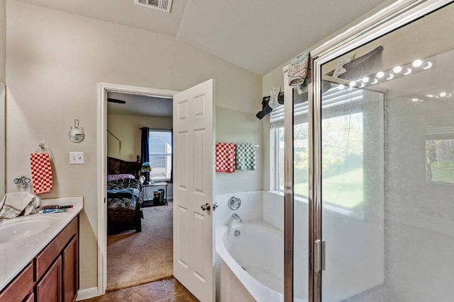604 Comal Run, Hutto, TX 78634 - ensuite bathroom with vanity, a bath, a shower stall, and healthy amount of natural light
