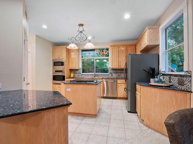 9402 Bluegrass Dr, Austin, TX 78759 - kitchen featuring appliances with stainless steel finishes, light brown cabinetry, tasteful backsplash, a kitchen island, and dark stone counters