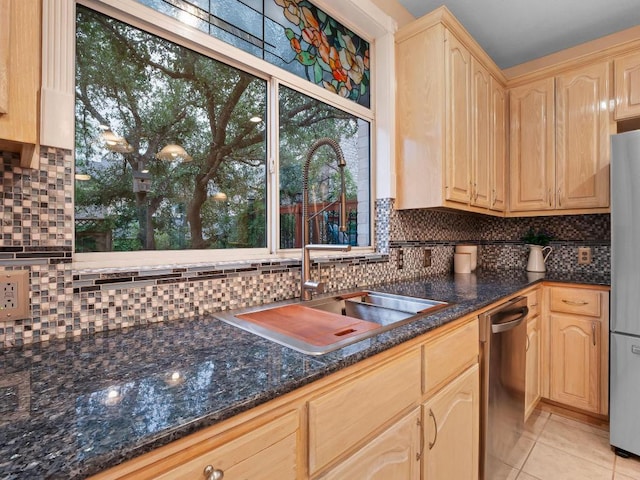 9402 Bluegrass Dr, Austin, TX 78759 - kitchen with backsplash, light tile patterned floors, appliances with stainless steel finishes, dark stone countertops, and light brown cabinetry