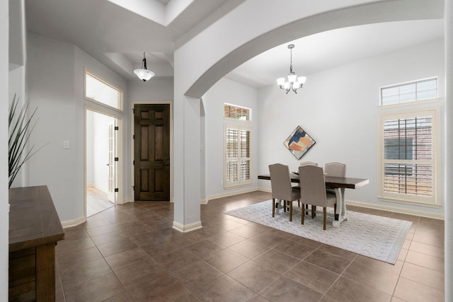 630 Wild Rose Dr, Austin, TX 78737 - dining area with arched walkways, dark tile patterned flooring, and a chandelier