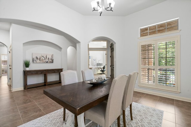 630 Wild Rose Dr, Austin, TX 78737 - dining area featuring tile patterned floors, plenty of natural light, arched walkways, and a chandelier