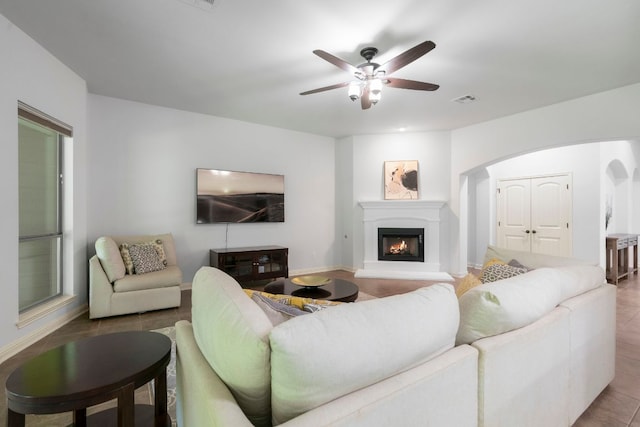 630 Wild Rose Dr, Austin, TX 78737 - living room featuring arched walkways, a ceiling fan, and a glass covered fireplace