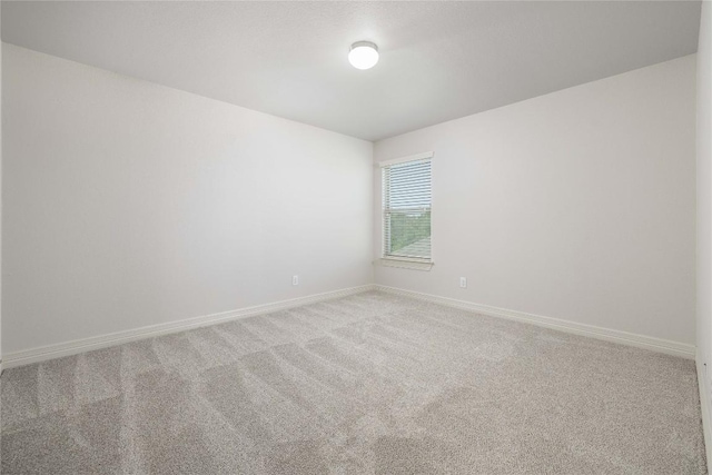 spare room with carpet and baseboards