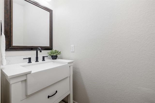 bathroom with a textured wall and vanity