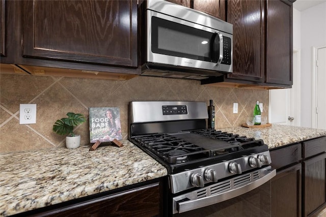 kitchen with stainless steel appliances, dark brown cabinets, and backsplash