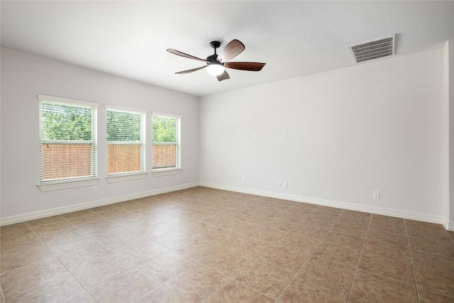 empty room featuring ceiling fan, baseboards, and light tile patterned flooring