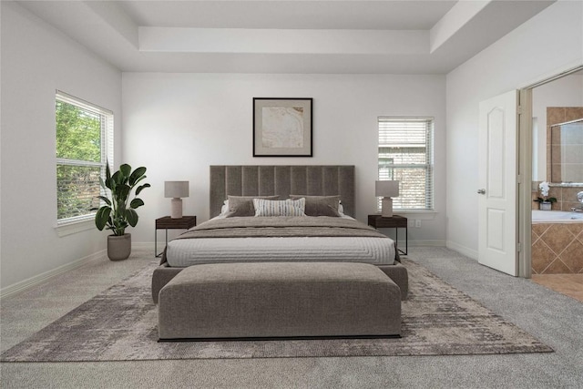 carpeted bedroom featuring multiple windows, a tray ceiling, and baseboards