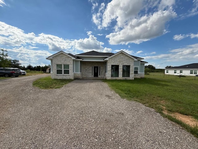 497 Brown Rd, Mcdade, TX 78650 - view of front of home with stone siding, driveway, and a front lawn