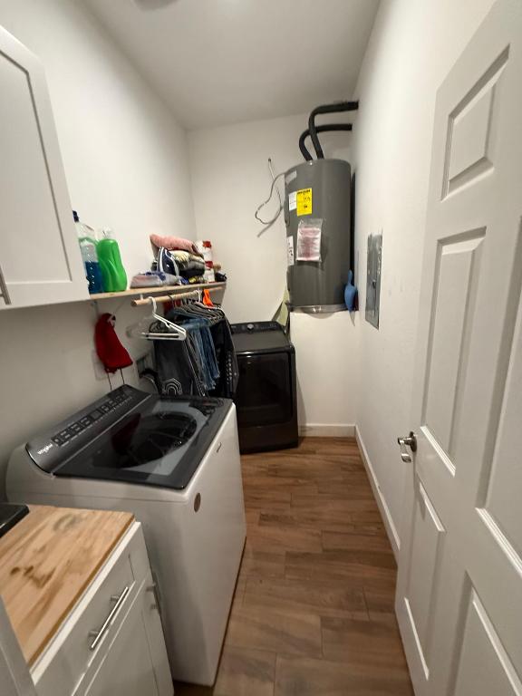 497 Brown Rd, Mcdade, TX 78650 - laundry room with cabinet space, electric water heater, separate washer and dryer, wood finished floors, and electric panel