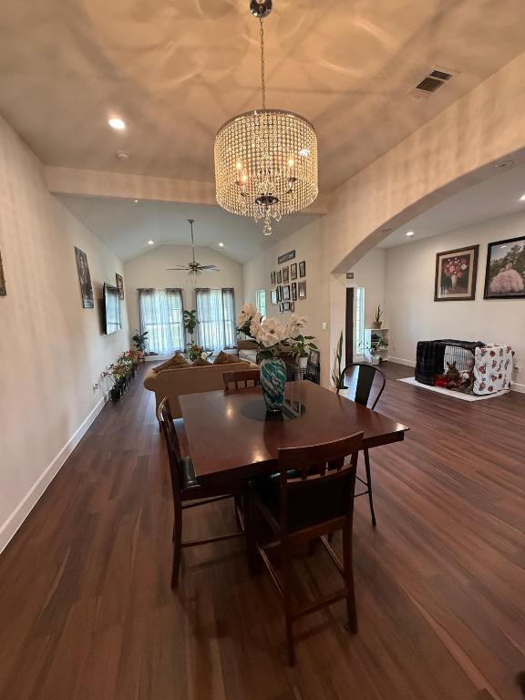 497 Brown Rd, Mcdade, TX 78650 - dining space with vaulted ceiling, arched walkways, wood finished floors, a chandelier, and ceiling fan