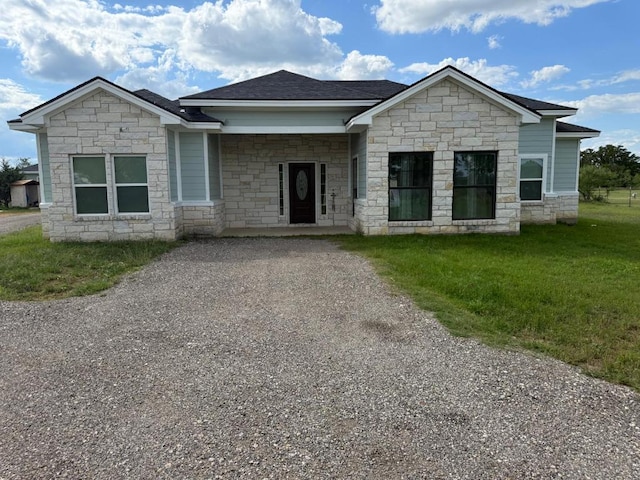 497 Brown Rd, Mcdade, TX 78650 - view of front of home featuring stone siding, a front lawn, and roof with shingles