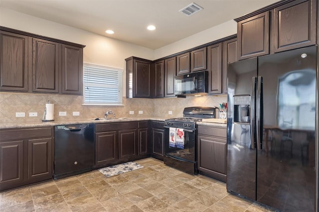 204 Mossberg Ln, Bastrop, TX 78602 - kitchen with black appliances, a sink, dark brown cabinetry, backsplash, and stone finish floors