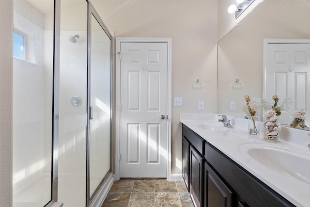 204 Mossberg Ln, Bastrop, TX 78602 - bathroom with a shower stall, double vanity, stone finish floors, and baseboards