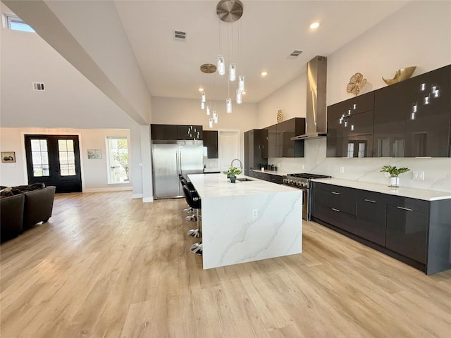 kitchen with extractor fan, premium appliances, modern cabinets, a towering ceiling, and a sink