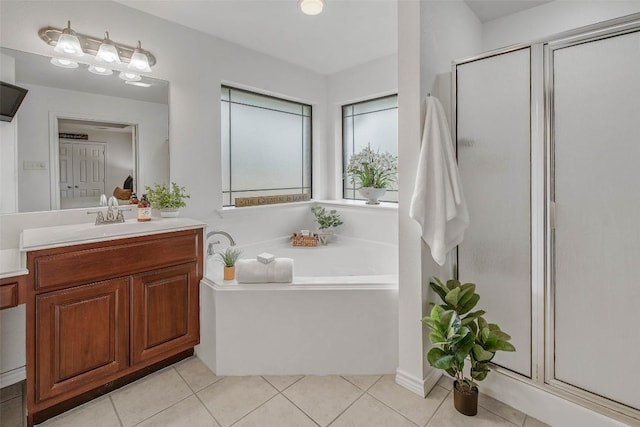 bathroom with a shower stall, tile patterned flooring, a bath, and vanity
