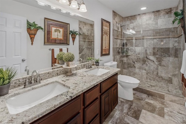 bathroom featuring toilet, a stall shower, double vanity, and recessed lighting