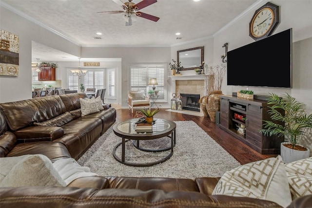 living area featuring wood finished floors, a tiled fireplace, ceiling fan, a chandelier, and recessed lighting