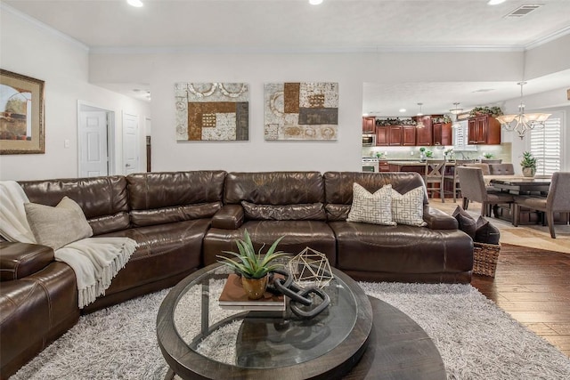 living area featuring crown molding, hardwood / wood-style flooring, recessed lighting, and a chandelier