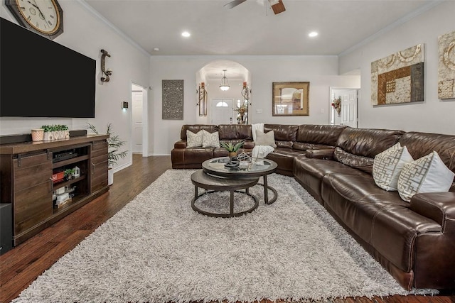 living area with dark wood finished floors, ceiling fan, arched walkways, crown molding, and recessed lighting