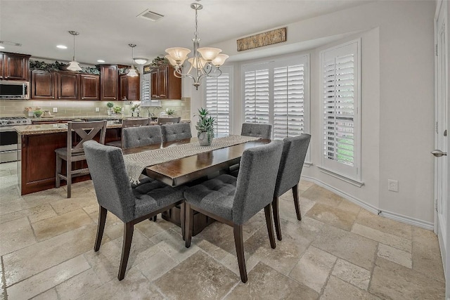 dining space featuring stone tile flooring, a chandelier, baseboards, and recessed lighting
