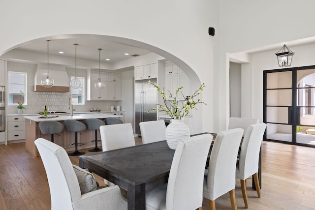 12625 Maidenhair Ln Unit 31, Austin, TX 78738 - dining area with light wood-style floors, arched walkways, recessed lighting, a tray ceiling, and a high ceiling