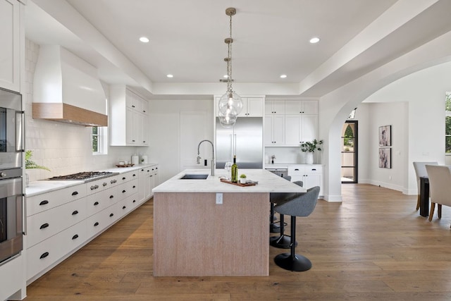 12625 Maidenhair Ln Unit 31, Austin, TX 78738 - kitchen with a sink, premium range hood, arched walkways, backsplash, and dark wood-style floors