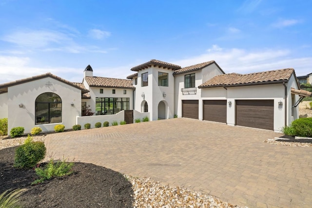 12625 Maidenhair Ln Unit 31, Austin, TX 78738 - mediterranean / spanish home with an attached garage, stucco siding, a tiled roof, and decorative driveway