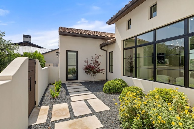 12625 Maidenhair Ln Unit 31, Austin, TX 78738 - view of property exterior with stucco siding, fence, a tile roof, and a gate
