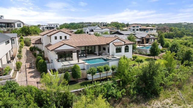 12625 Maidenhair Ln Unit 31, Austin, TX 78738 - back of house featuring a residential view, stucco siding, a tile roof, and a pool with connected hot tub