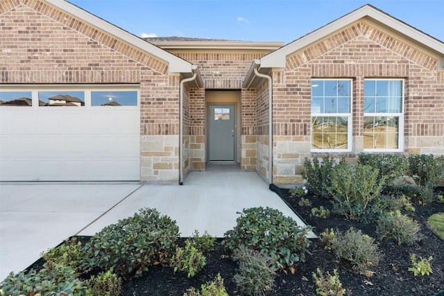 552 Tekoa Dr, Georgetown, TX 78628 - property entrance featuring brick siding, an attached garage, stone siding, and concrete driveway