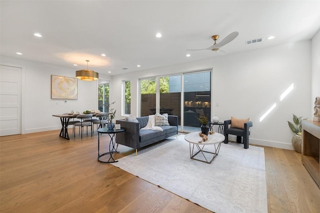 living area featuring recessed lighting, light wood-style floors, baseboards, and ceiling fan