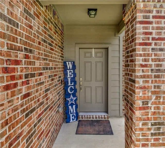 doorway to property with brick siding
