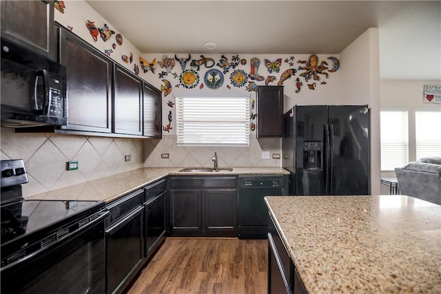 kitchen with black appliances, a sink, plenty of natural light, and wood finished floors
