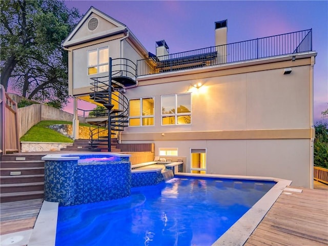 5801 Cannonade Ct, Austin, TX 78746 - back of property featuring stairway, a balcony, a fenced backyard, a pool with connected hot tub, and stucco siding