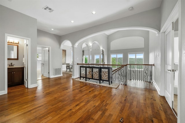 5801 Cannonade Ct, Austin, TX 78746 - hall featuring wood finished floors, recessed lighting, arched walkways, a high ceiling, and an upstairs landing