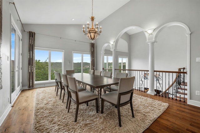 5801 Cannonade Ct, Austin, TX 78746 - dining area featuring wood finished floors, a chandelier, ornate columns, arched walkways, and high vaulted ceiling