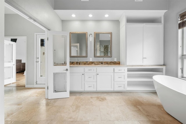 5801 Cannonade Ct, Austin, TX 78746 - full bathroom with double vanity, a freestanding tub, and recessed lighting