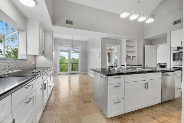 5801 Cannonade Ct, Austin, TX 78746 - kitchen with stainless steel dishwasher, dark countertops, decorative backsplash, a kitchen island with sink, and a towering ceiling