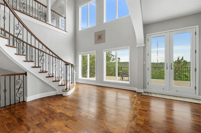 5801 Cannonade Ct, Austin, TX 78746 - entrance foyer with healthy amount of natural light, a towering ceiling, wood finished floors, and stairway