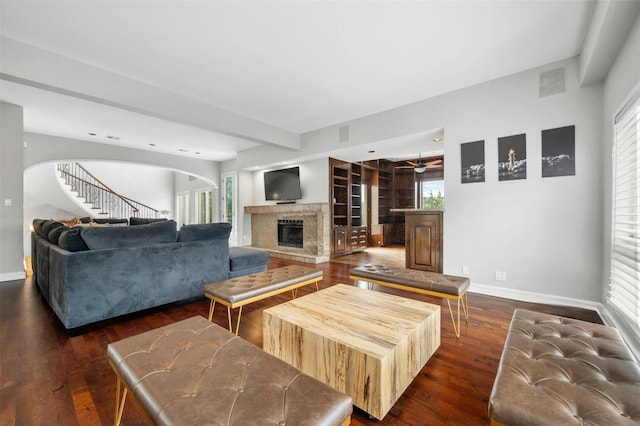 5801 Cannonade Ct, Austin, TX 78746 - living area featuring a fireplace with raised hearth, dark wood-style floors, arched walkways, and stairs