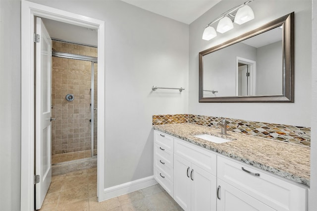 bathroom featuring a stall shower, vanity, and baseboards
