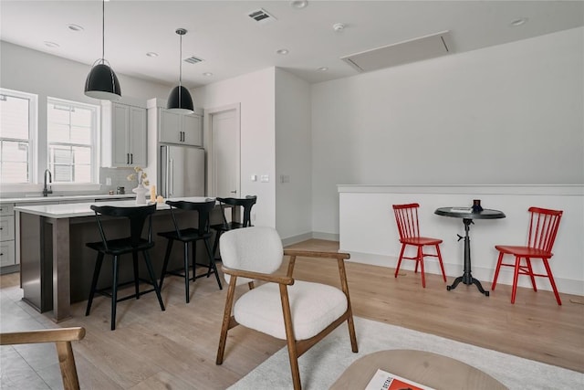 2209 Woodland Ave Unit 501, Austin, TX 78741 - kitchen featuring high end refrigerator, a breakfast bar, a kitchen island, light wood-style floors, and light countertops